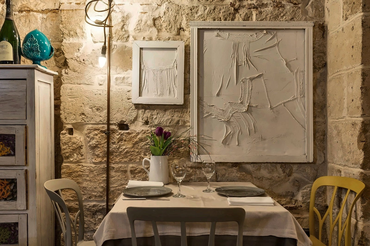 A table laid against a bare stone wall at La Cecchina