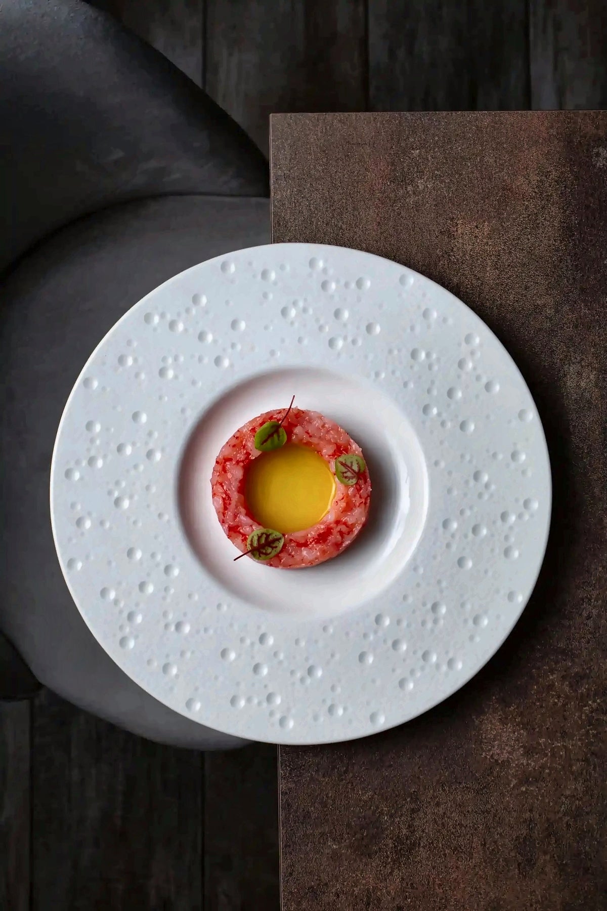 Red prawn tartare on a textured white plate at Radicale