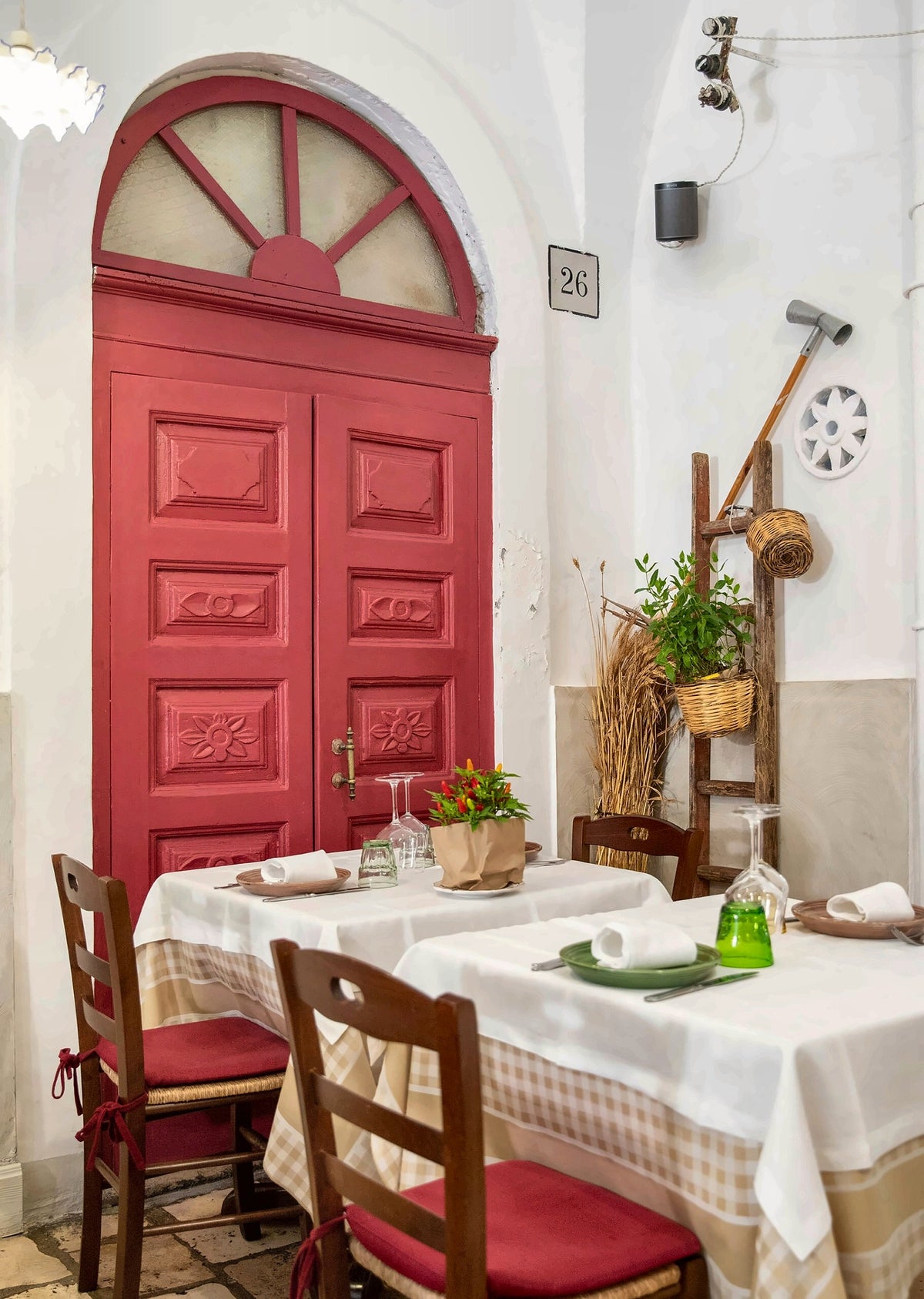 Tables beside a red door in the courtyard of Terranima