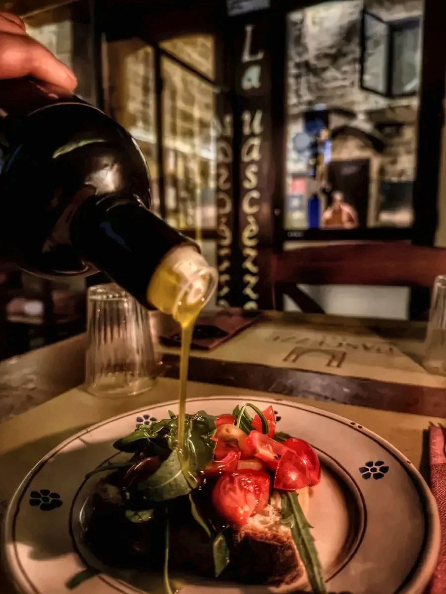 Olive oil poured over a tomato bruschetta at La Uascezze