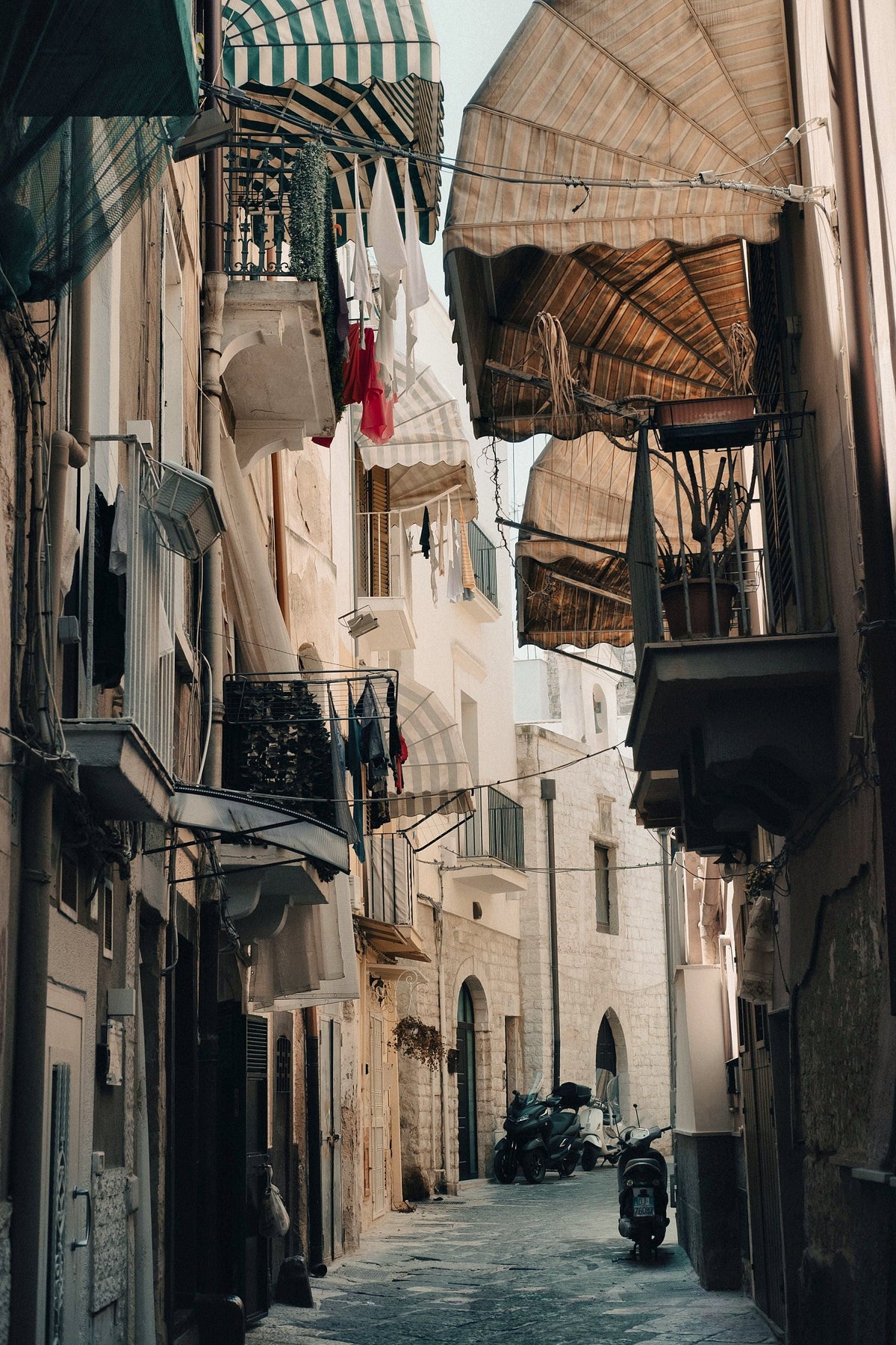Awnings, balconies and a parked scooter in a narrow alley