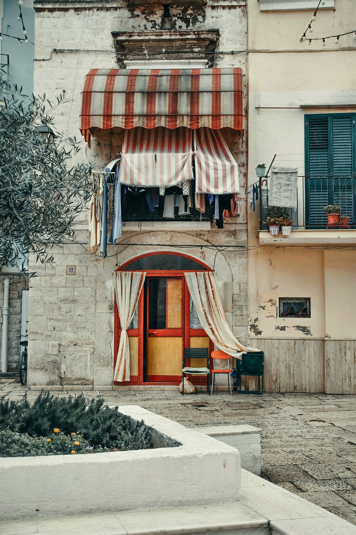 A striped awning and painted door on a small square of the old town