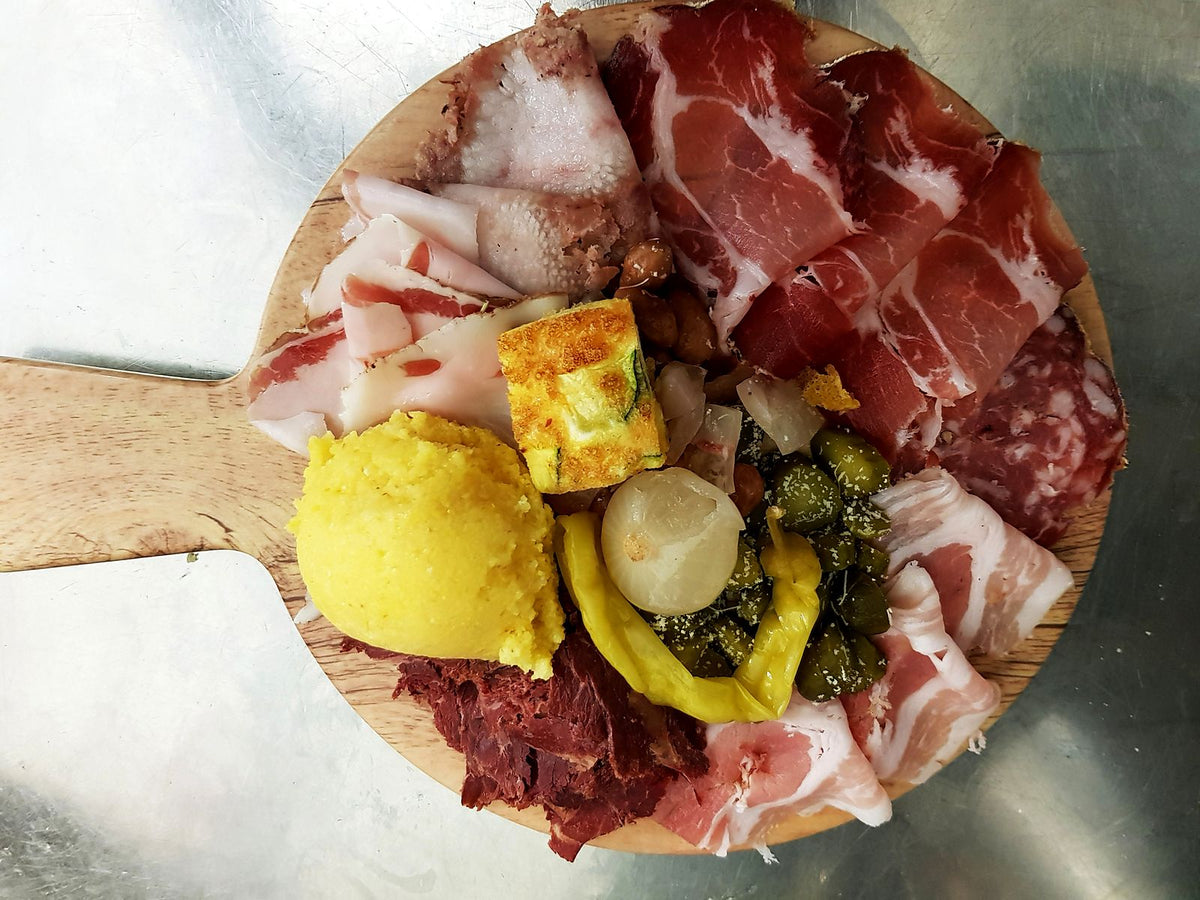Board of cured meats and pickles at Antica Trattoria La Colombina