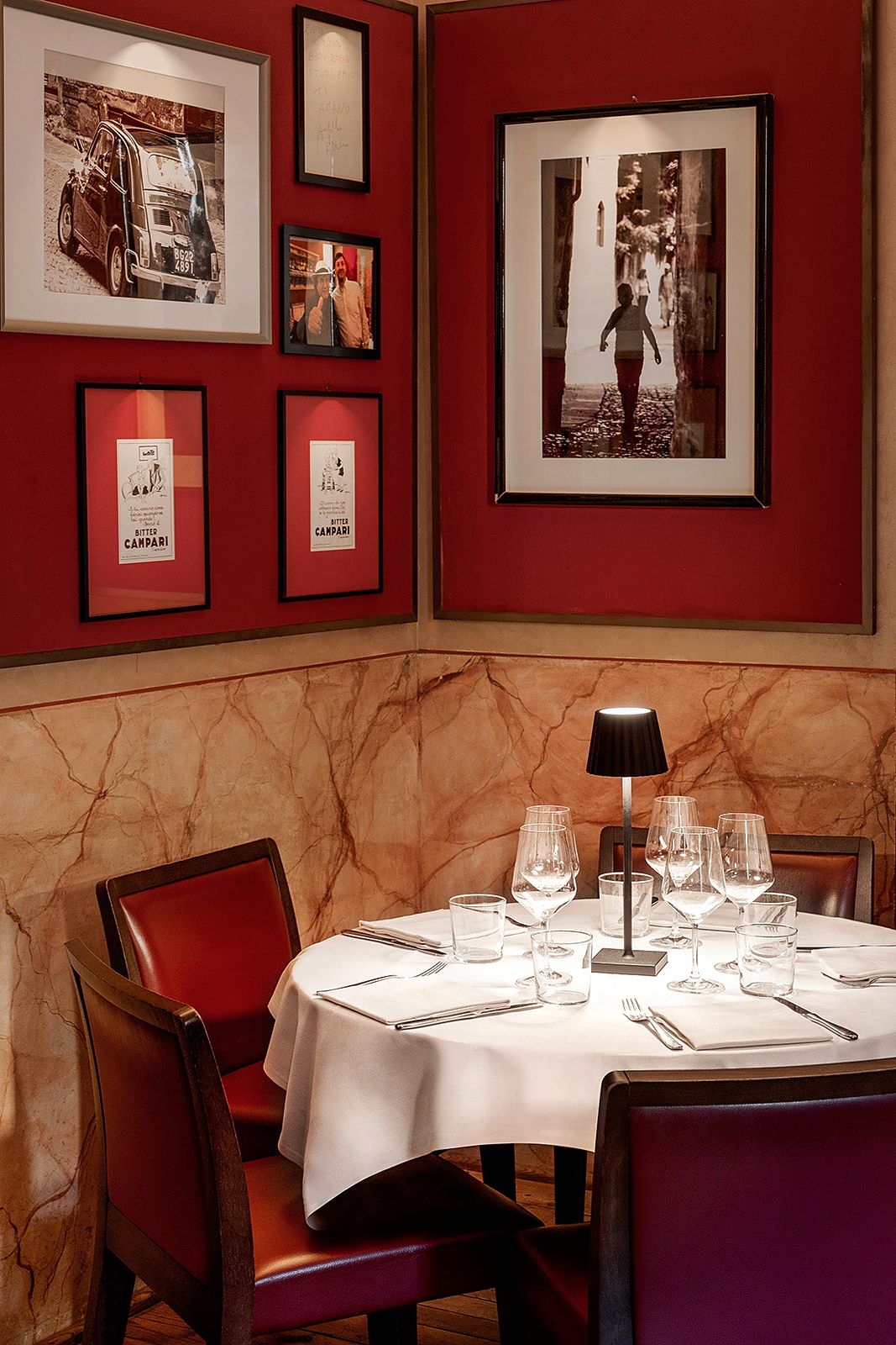 Red dining room hung with photographs at Caffè del Tasso