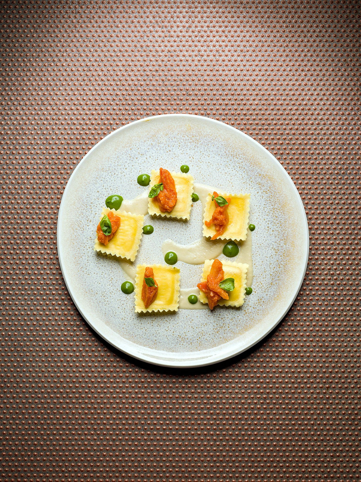 Filled pasta with vegetable garnish at Amocù