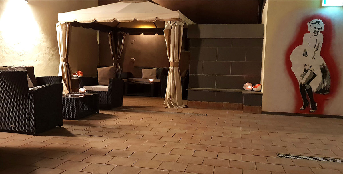 Courtyard lounge with a gazebo and wicker sofas at Art & Jazz Hotel