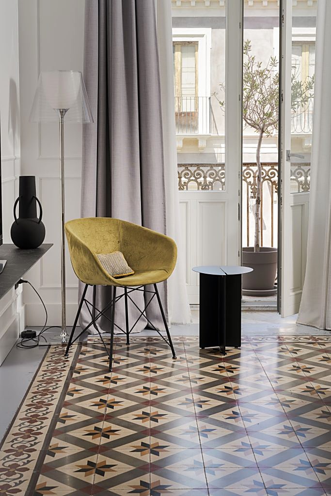 Guest room with patterned cement-tile floor and balcony doors at Habitat Boutique Hotel