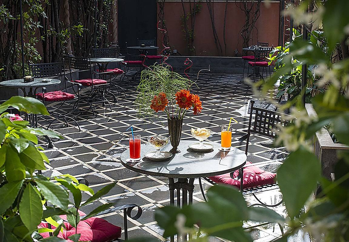 Inner garden courtyard with wrought-iron tables at Liberty Hotel