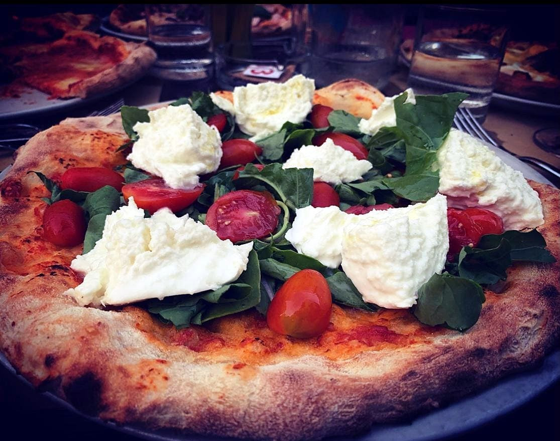 Pizza with burrata, cherry tomatoes and greens at Locanda Cerami