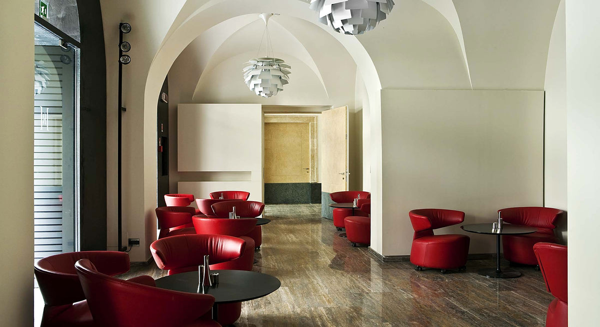 Lounge with red armchairs under vaulted ceilings at Romano House