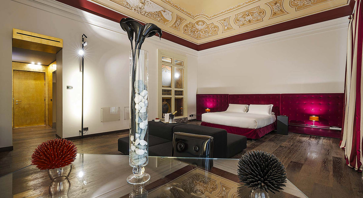 Suite with frescoed ceiling and contemporary design furniture at Romano House