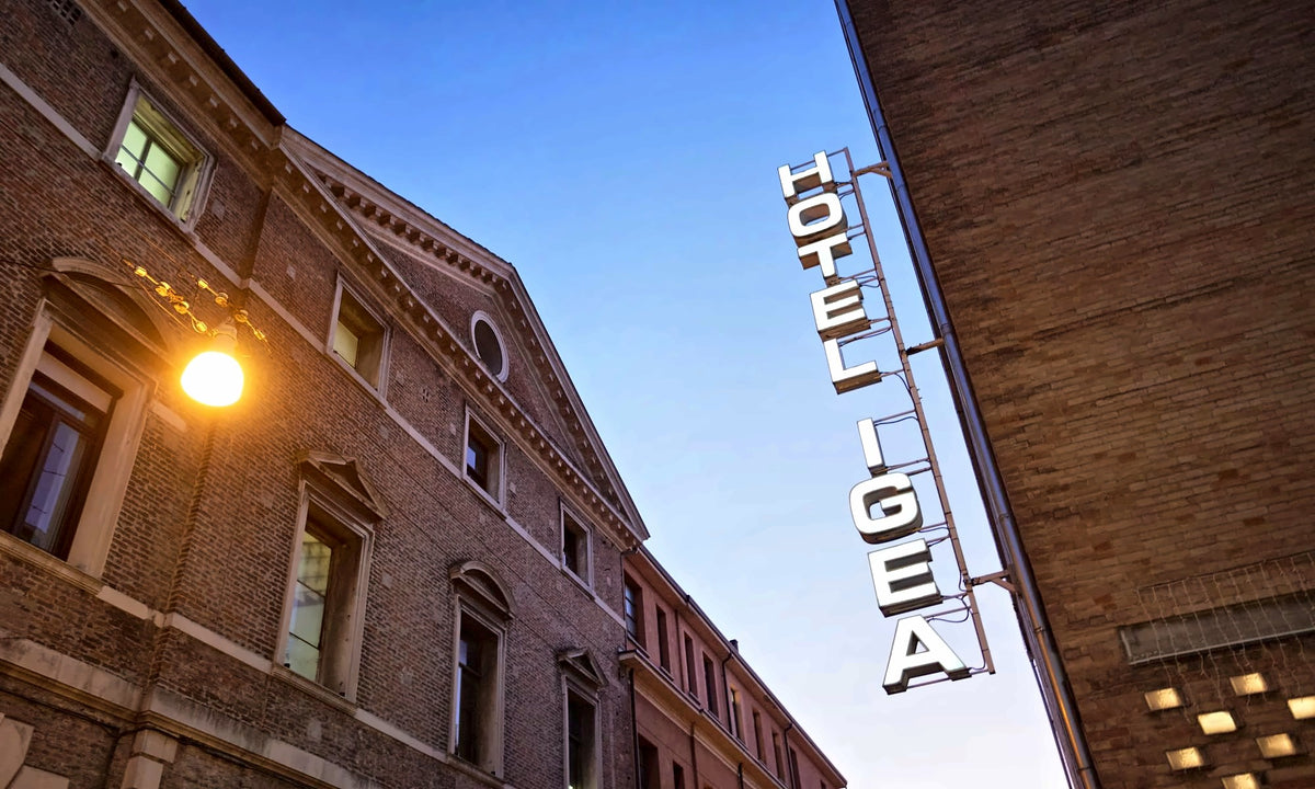 Hotel Igea vertical sign on a brick building at dusk, Padua