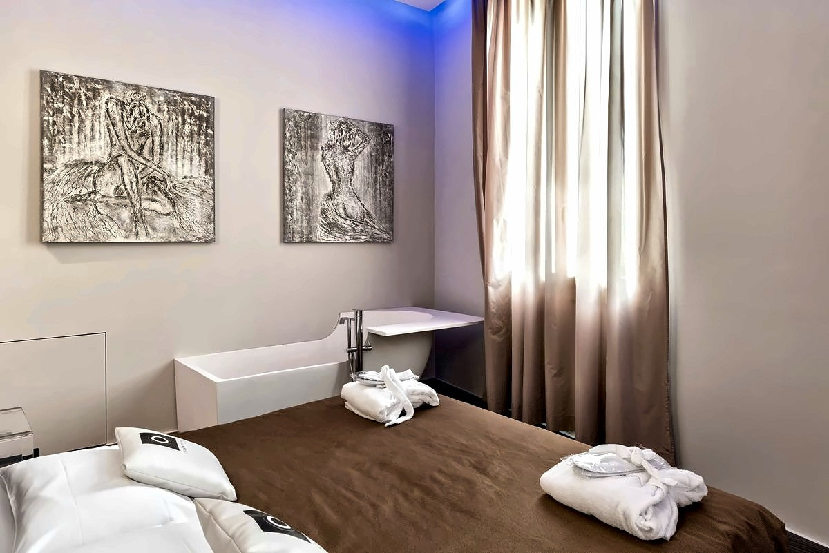 Suite at Le Camp Suite & SPA with freestanding bathtub, art prints and brown bedspread