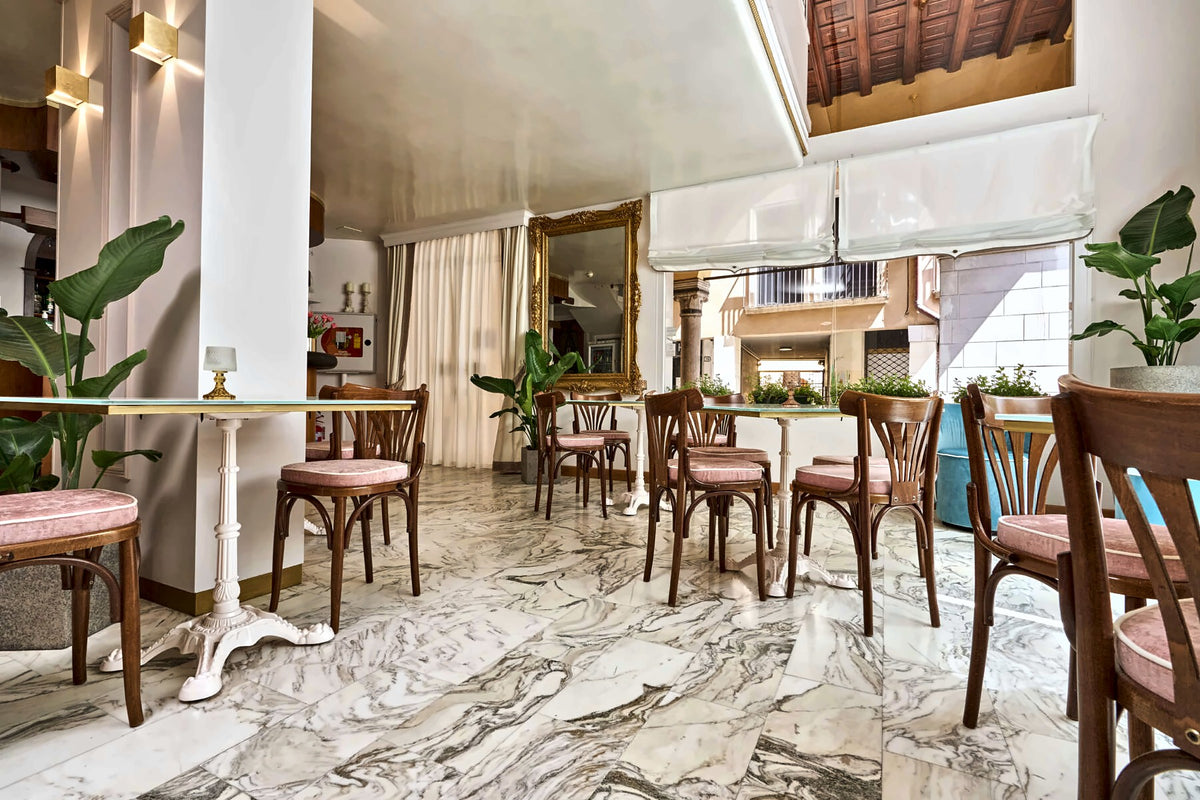 Breakfast lounge at Hotel Majestic Toscanelli with marble floor and bistro tables