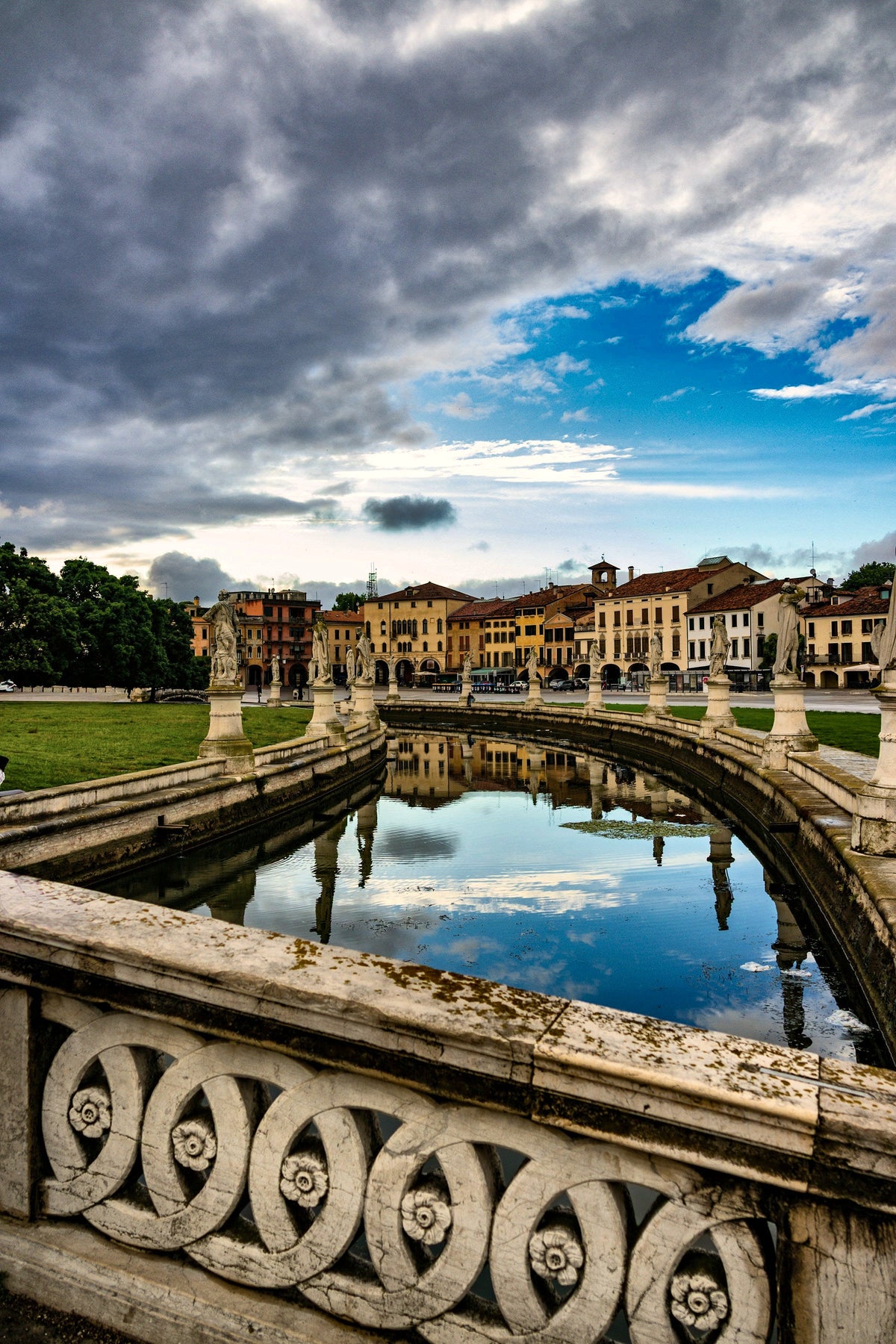 Clouds reflected in the canal beside the stone balustrade of Prato della Valle