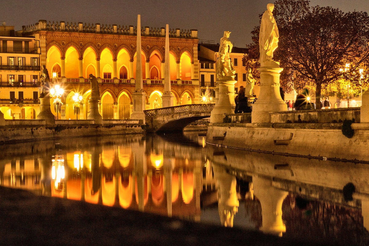 Prato della Valle at night, the Loggia Amulea glowing in the canal