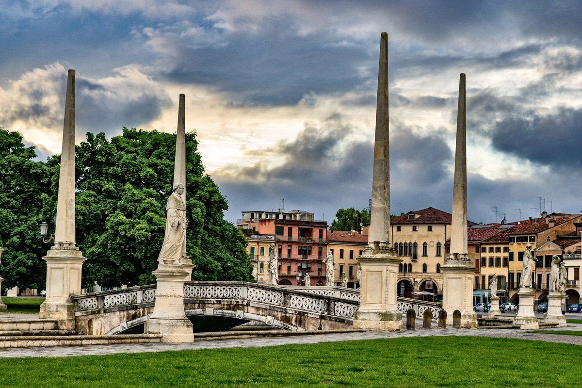 Obelisks and statues around the Isola Memmia under a stormy sky