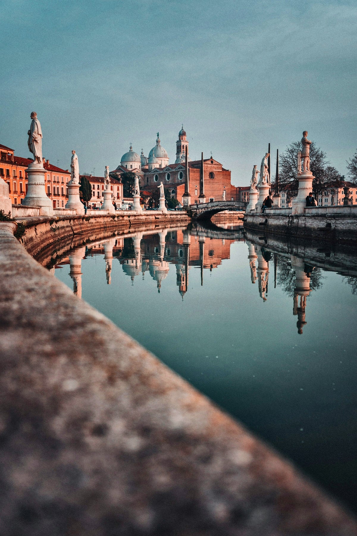 Statues and domes mirrored in the canal of Prato della Valle