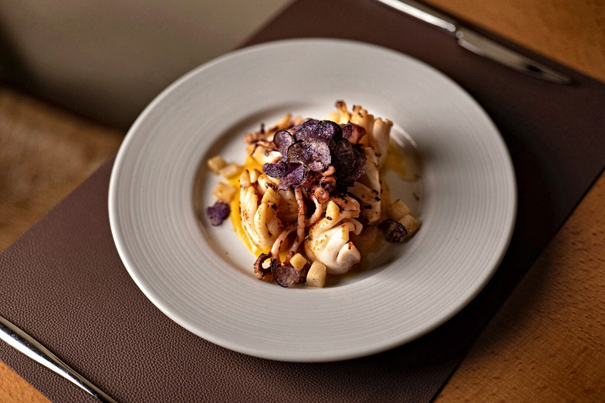 Pasta with seafood in a white bowl at Enotavola Pino, Padua