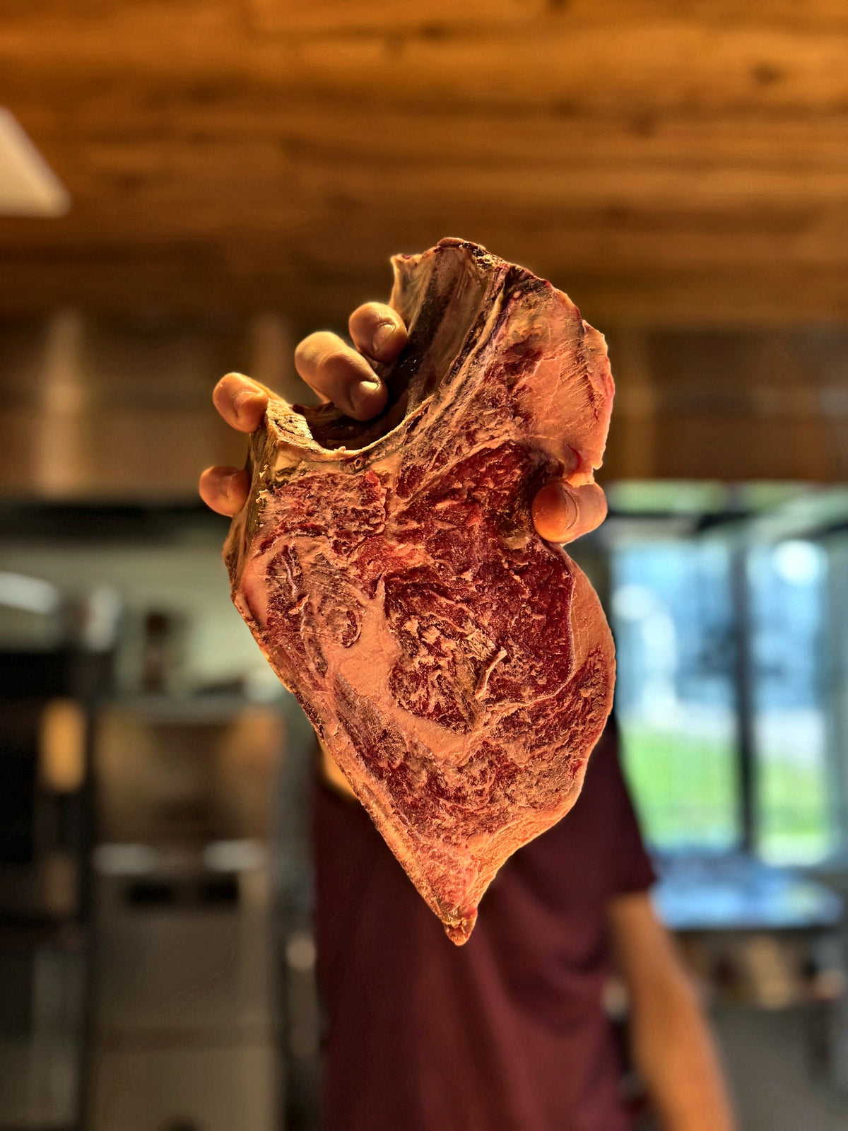 Raw bone-in beef steak held up in the dining room at Gino's, Padua