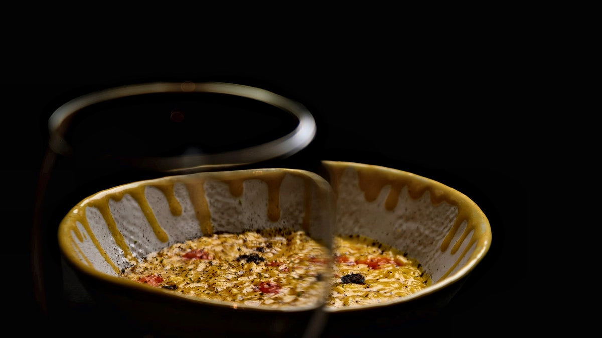 Risotto in a gold-glazed ceramic bowl at Le Calandre, Rubano