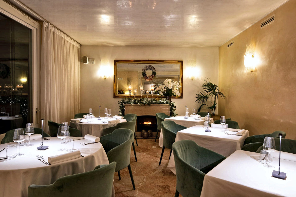 Dining room with fireplace and gilt mirror at Villa Tevere, Padua