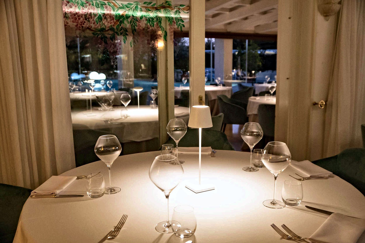 Table set with wine glasses under a small lamp at Villa Tevere, Padua