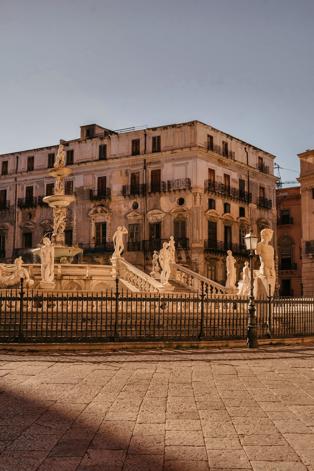 The marble statues and stairs of the Fontana Pretoria in warm light