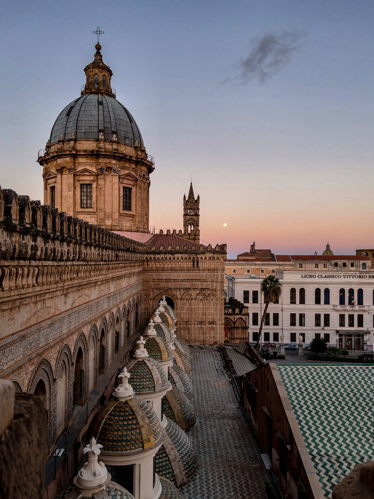 The rooftops of Palermo Cathedral at dusk, with the dome and pinnacles
