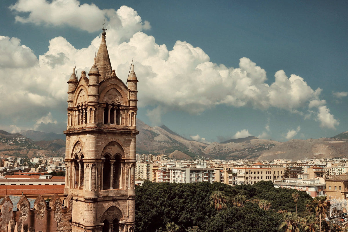 A cathedral bell tower against the mountains that ring Palermo