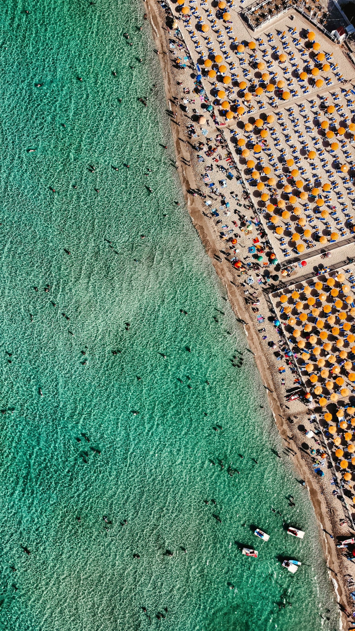 Rows of umbrellas along the shore at Mondello, from above