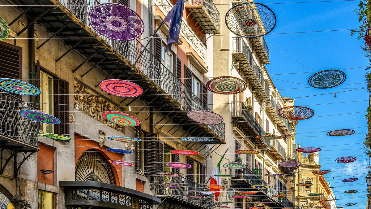 Crochet decorations hung between the balconies of a street