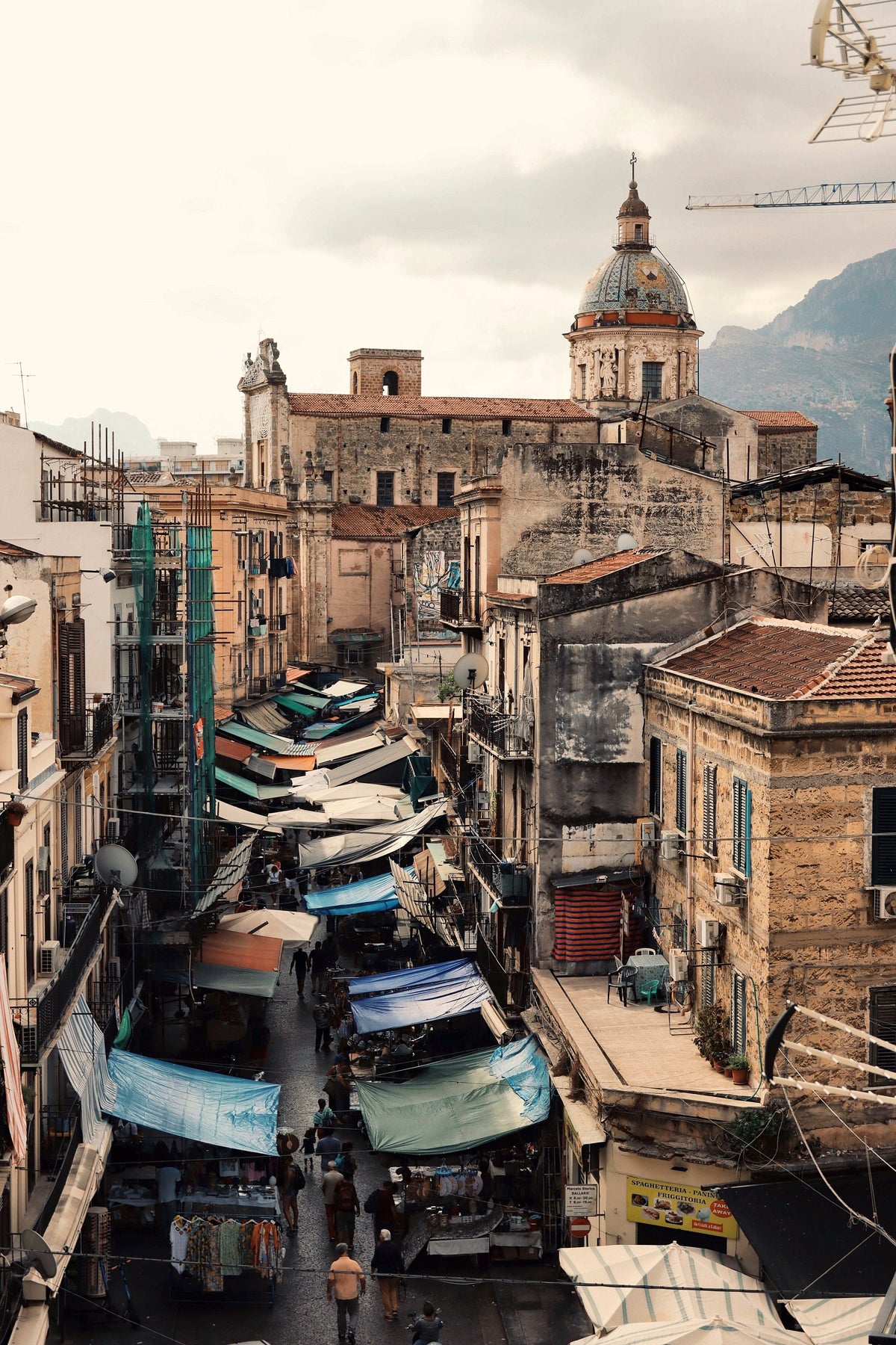 Market awnings filling a street of the old town, seen from above