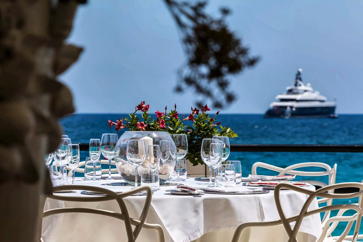 Tables laid with flowers on the seafront terrace of Alle Terrazze