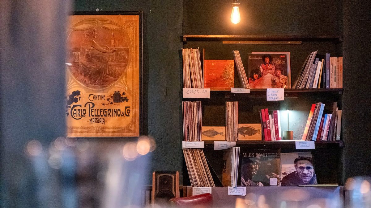 Shelves of vinyl records and books at Buatta Cucina Popolana