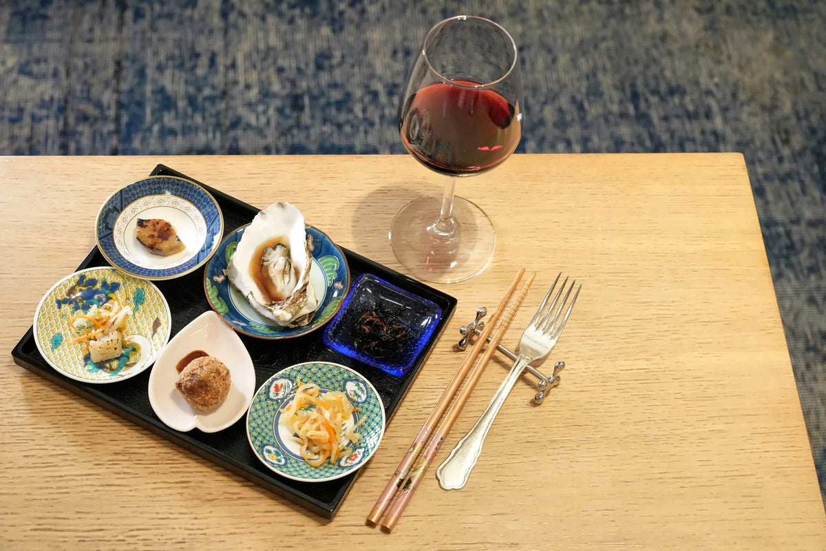 An oyster and small tasting plates with a glass of red at Bye Bye Blues