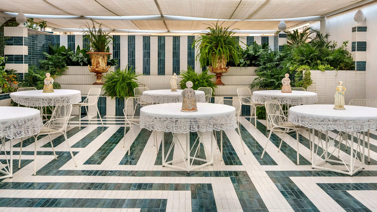 White tables among plants on the terrace of Charleston