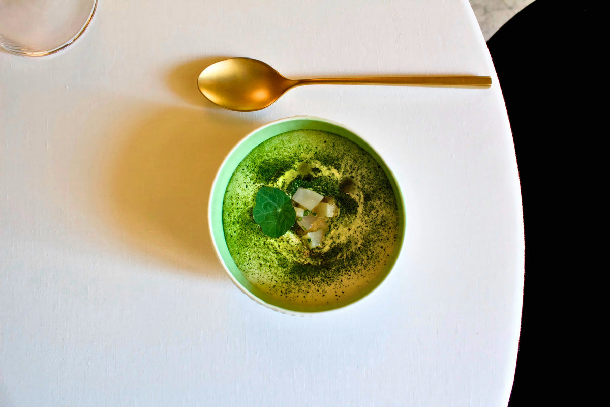 A bright green soup on white linen at Mec Restaurant