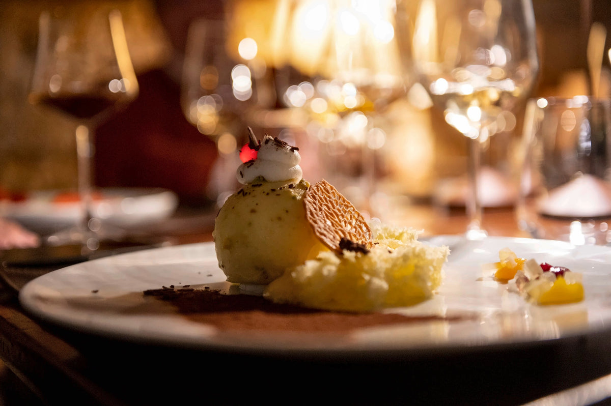 A plated dessert in warm candlelight at Osteria Ballarò