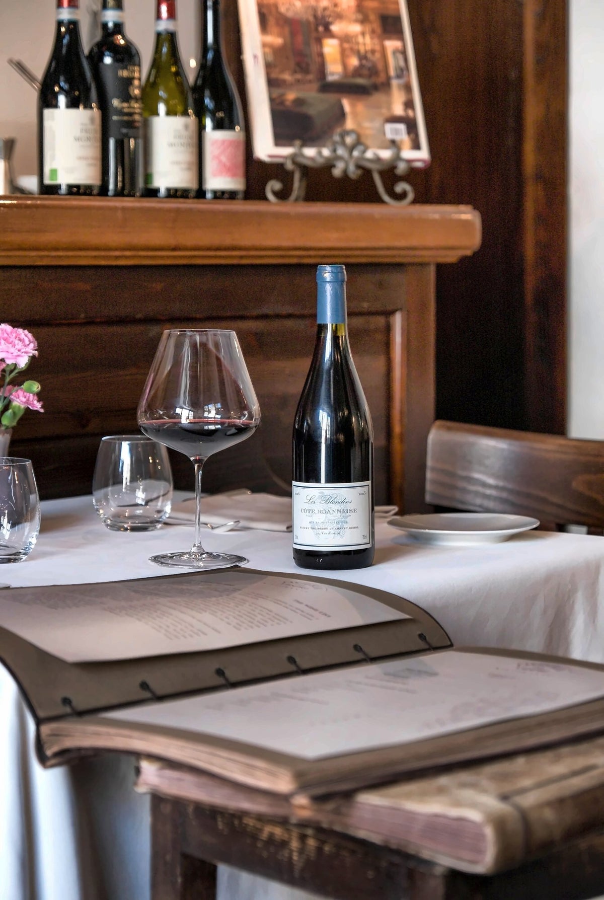 A bottle of wine on a set table at Osteria dei Vespri