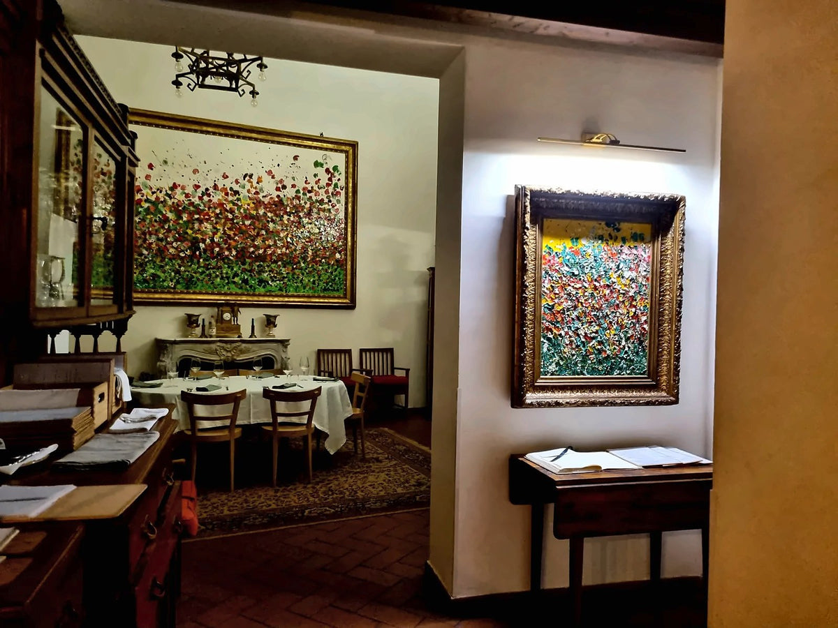 The dining room of Quattro Mani with its large colourful paintings
