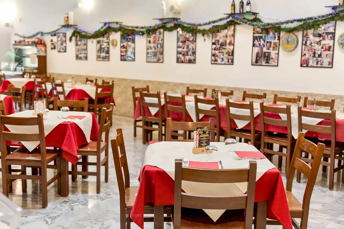 Red and white tables in the dining room of Trattoria del Massimo