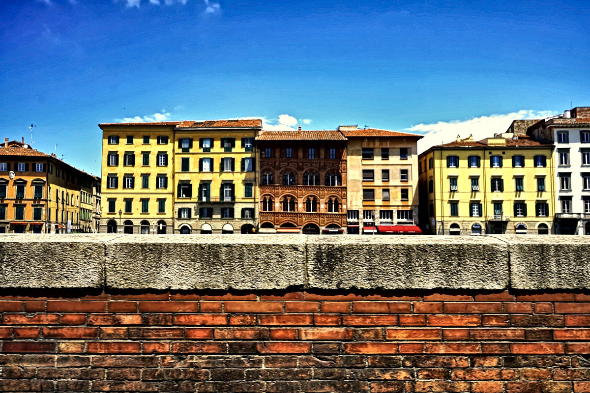 Colourful palazzi above the brick embankment of the Arno