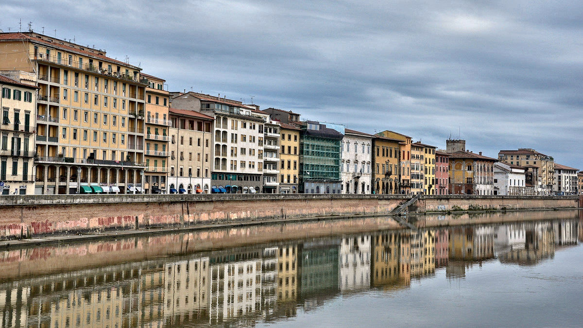 Pastel facades of the Lungarno mirrored in a still Arno