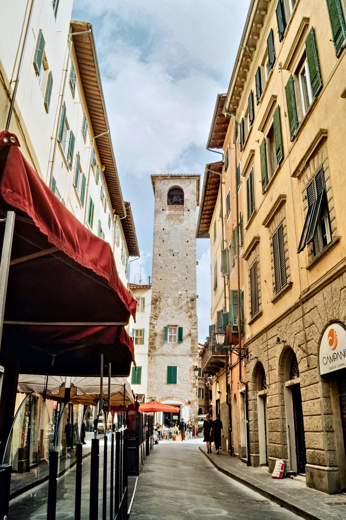 An old-town street leading to a medieval tower