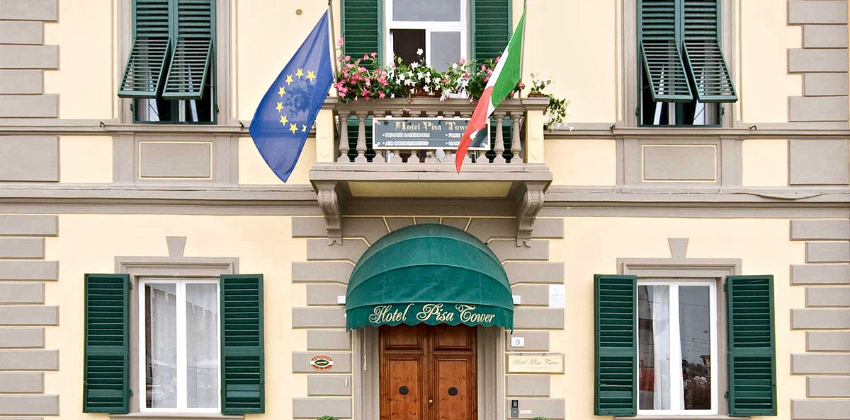 The facade and green awning of Hotel Pisa Tower