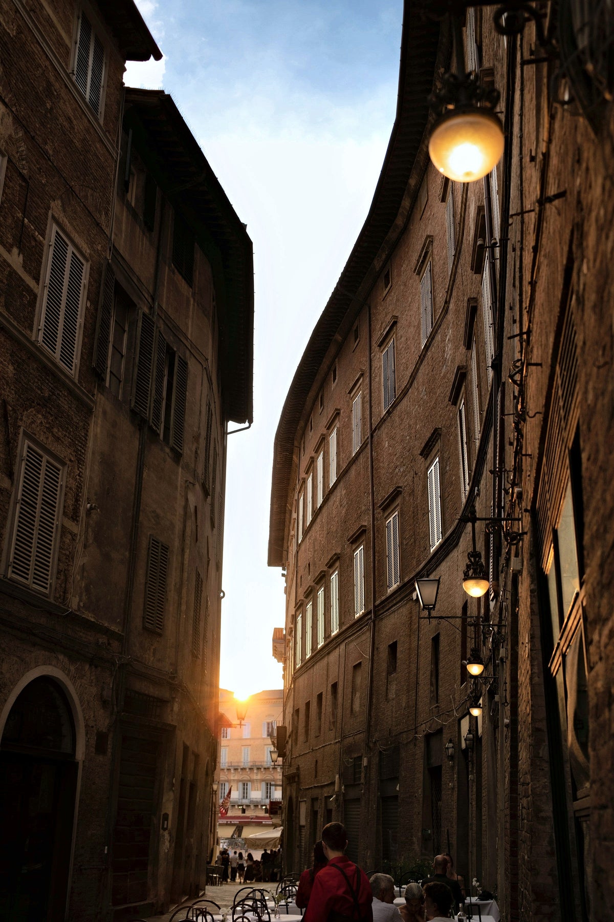 The sun setting at the end of a narrow street