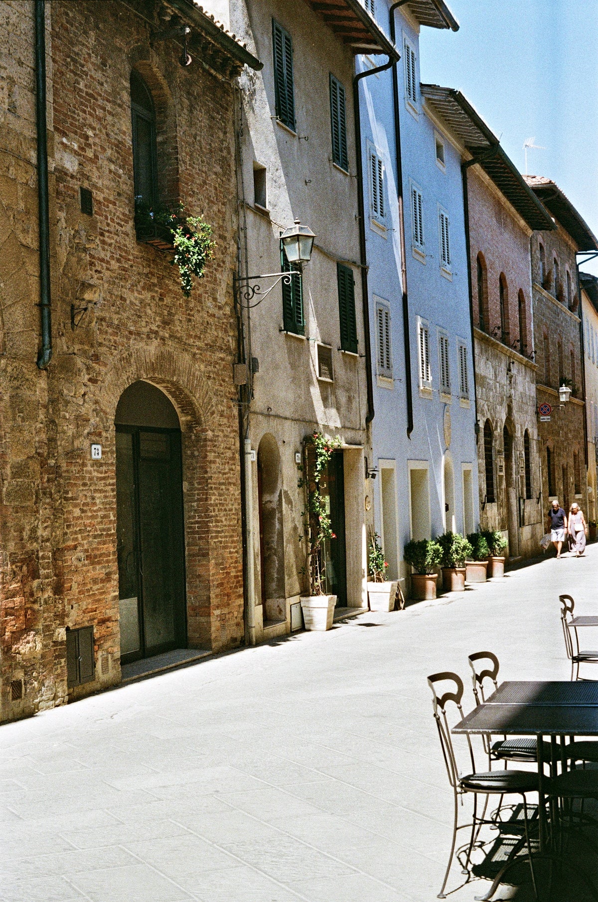 Cafe tables on a quiet street in San Quirico d’Orcia