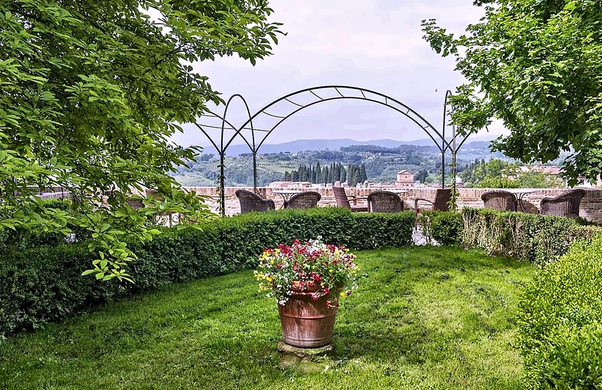 Garden with an iron pergola and views of the Sienese hills at Palazzo Ravizza