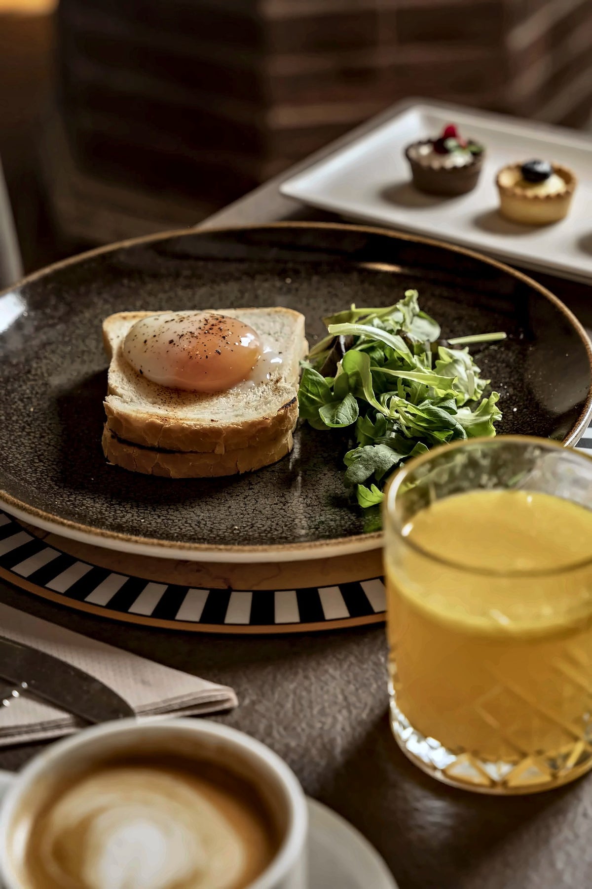 Breakfast with an egg on toast, orange juice and cappuccino at Hotel Athena